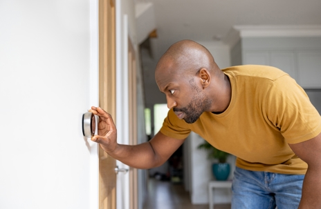 Man adjusting the temperature on the thermostat.